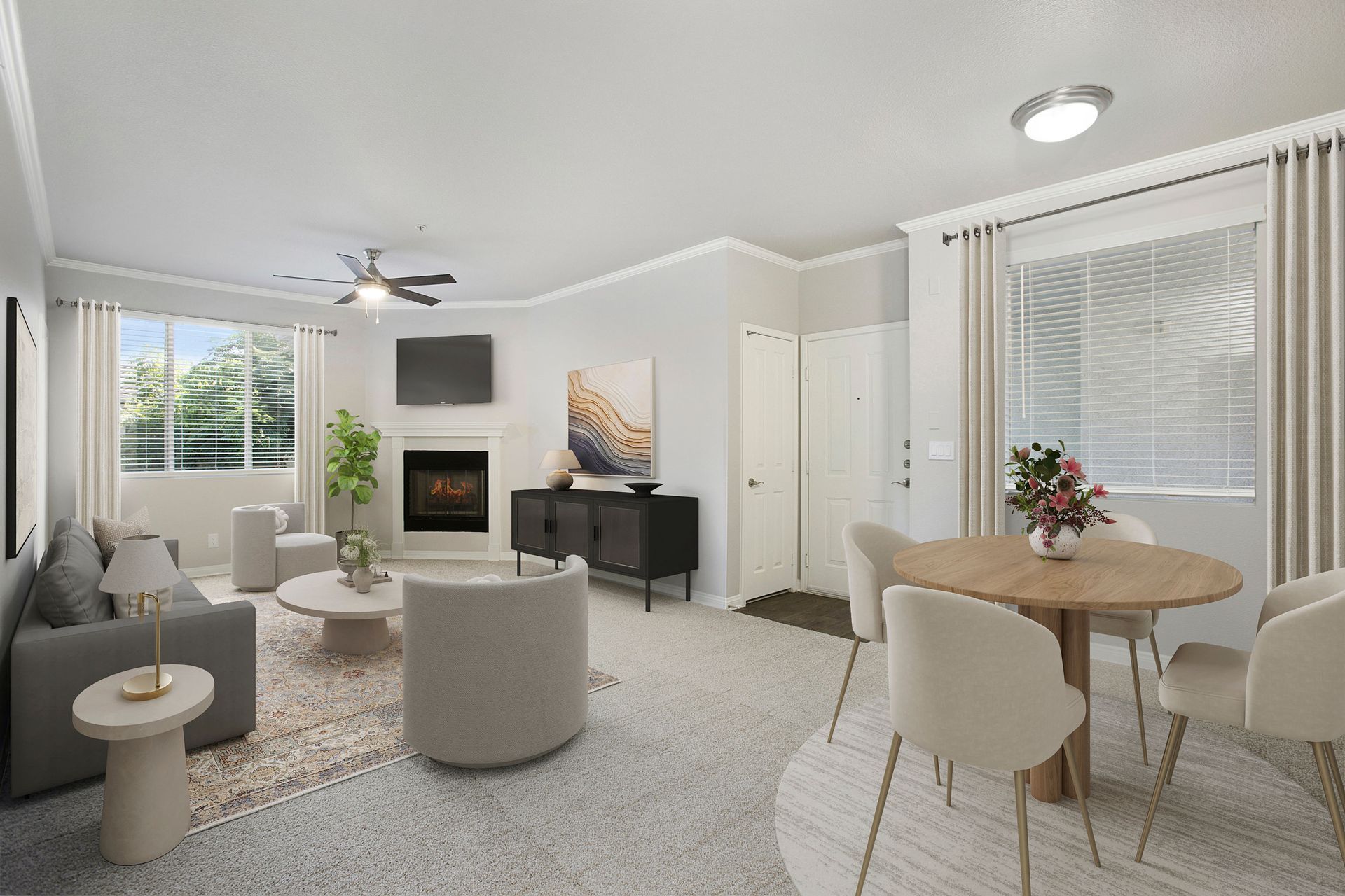 Bright apartment living room with sofa, fireplace, wall TV, and round dining table at Alicante Apartments in Aliso Viejo, CA.
