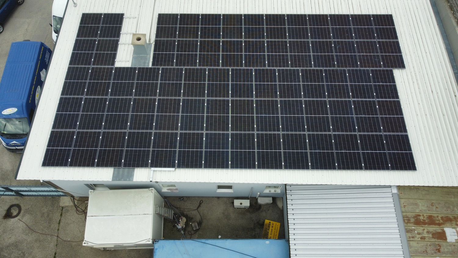 Eine Luftaufnahme eines Gebäudes mit Solarmodulen auf dem Dach.