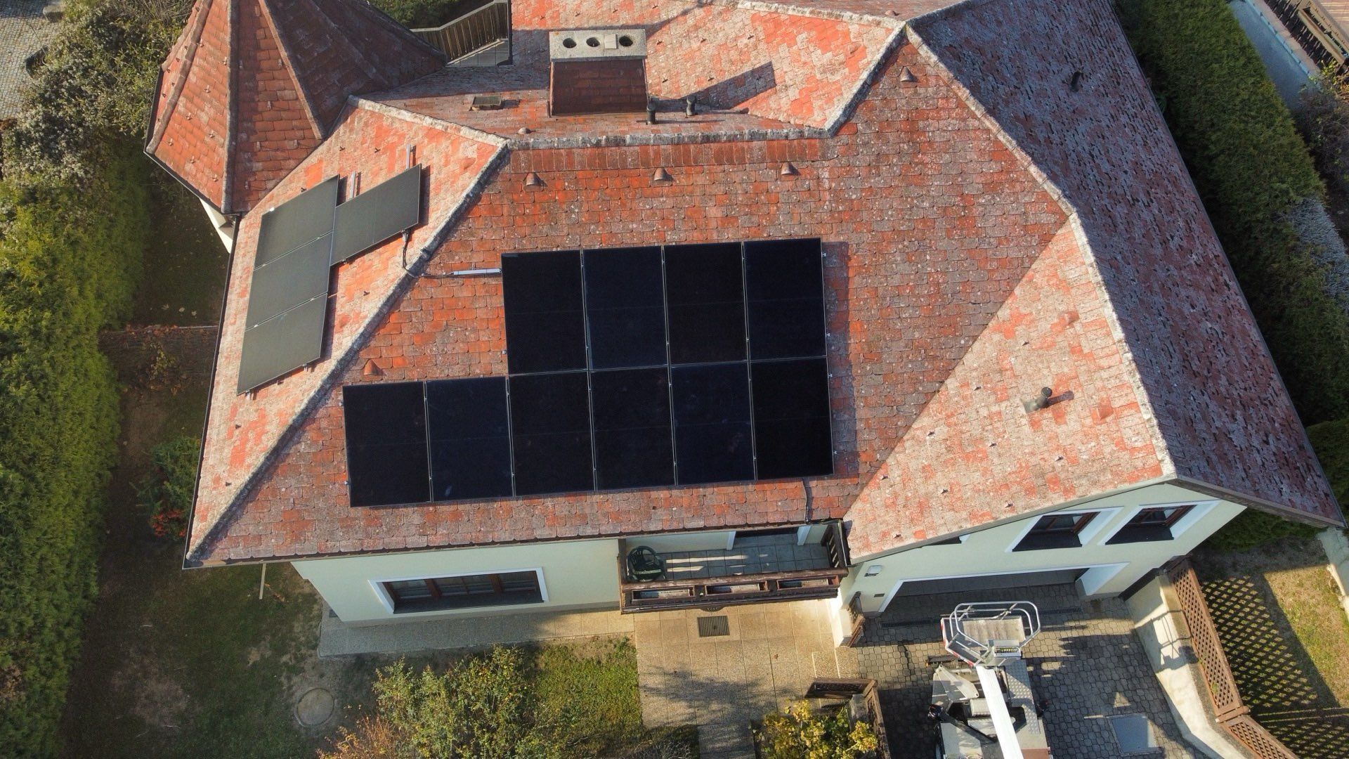 Eine Luftaufnahme eines Hauses mit Solarmodulen auf dem Dach.