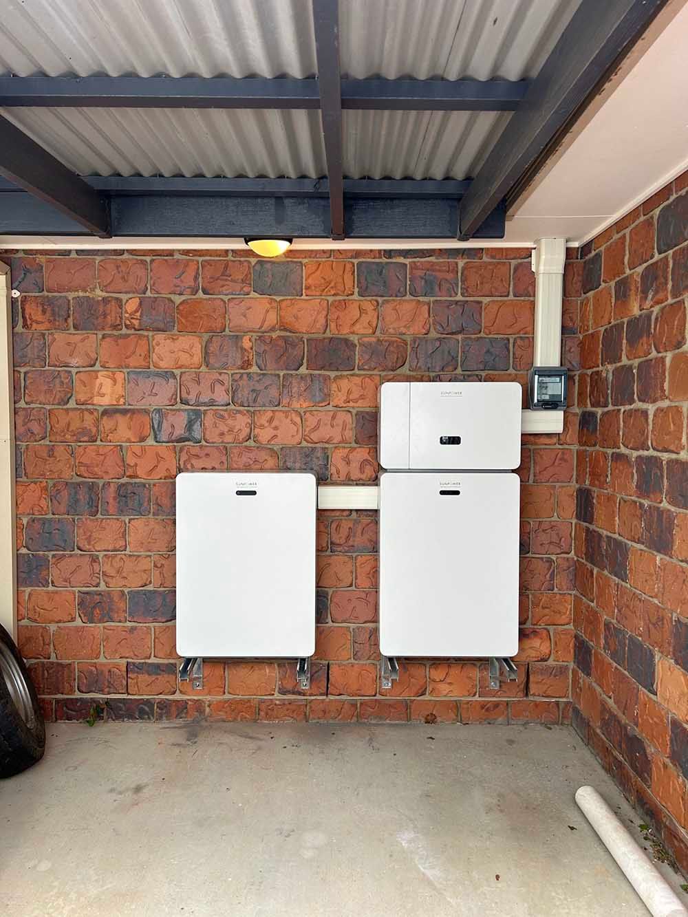 Two Solar Panels Mounted On A Brick Wall In A Garage — Goulburn Solar In Goulburn, NSW