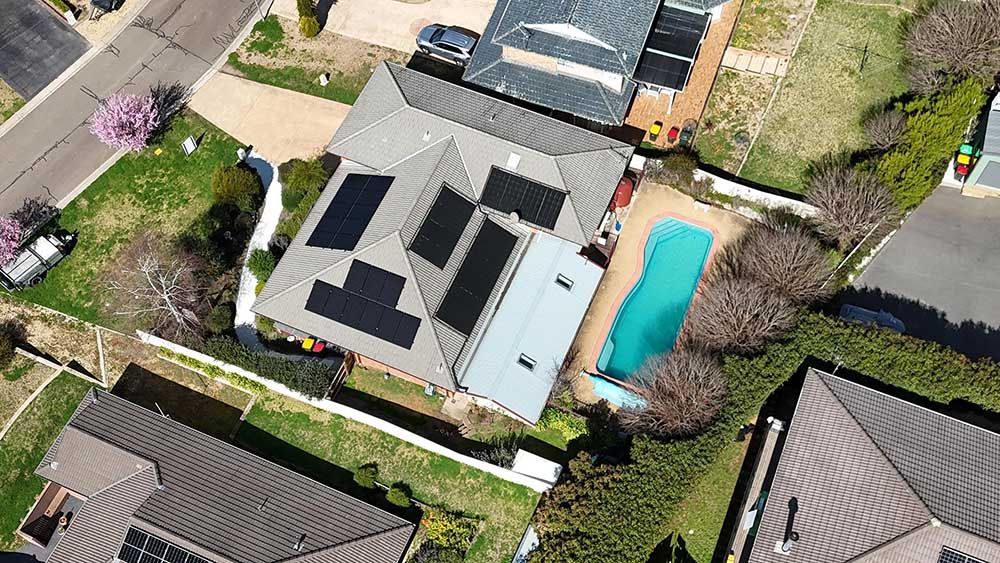 Aerial View Of A House With Solar Panels On The Roof And A Pool — Goulburn Solar In Merimbula, NSW
