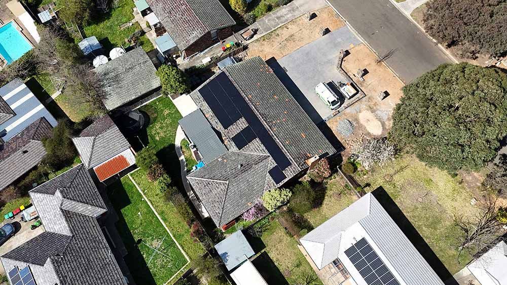 Aerial View Of A Residential Area With Lots Of Houses And Solar Panels On The Roofs — Goulburn Solar In Narooma, NSW