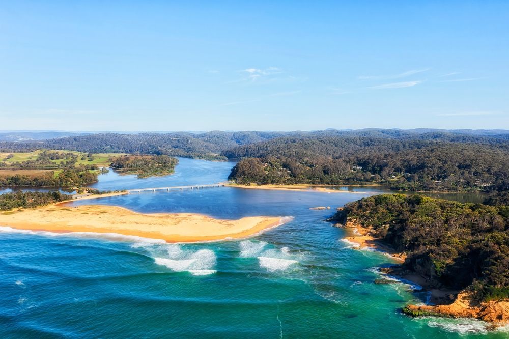 Aerial View Of A Body Of Water Surrounded By Trees And A Beach — Goulburn Solar In Bega, NSW