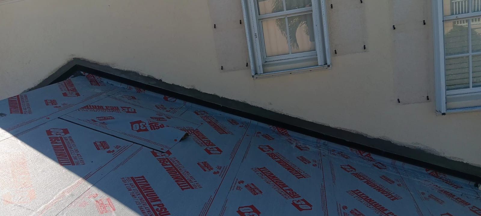 Roof underlayment being installed near windows.