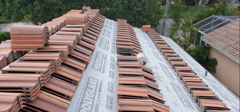 A tiled roof under construction with some tiles already in place and others still being installed.