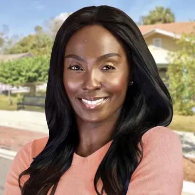 Woman with long black hair smiles, blurred suburban background.