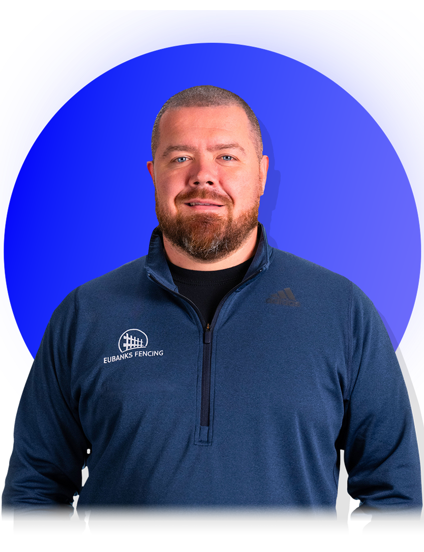 Man in navy quarter-zip standing before a blue circular backdrop, facing forward with a neutral expression