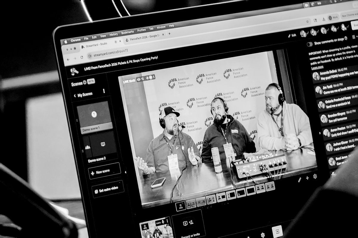 Laptop screen showing a black-and-white video call with three people and a chat sidebar