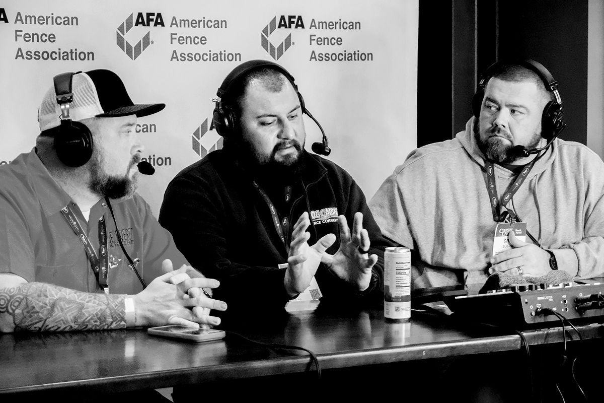 Three men wearing headphones speak at a table during a podcast or panel discussion.