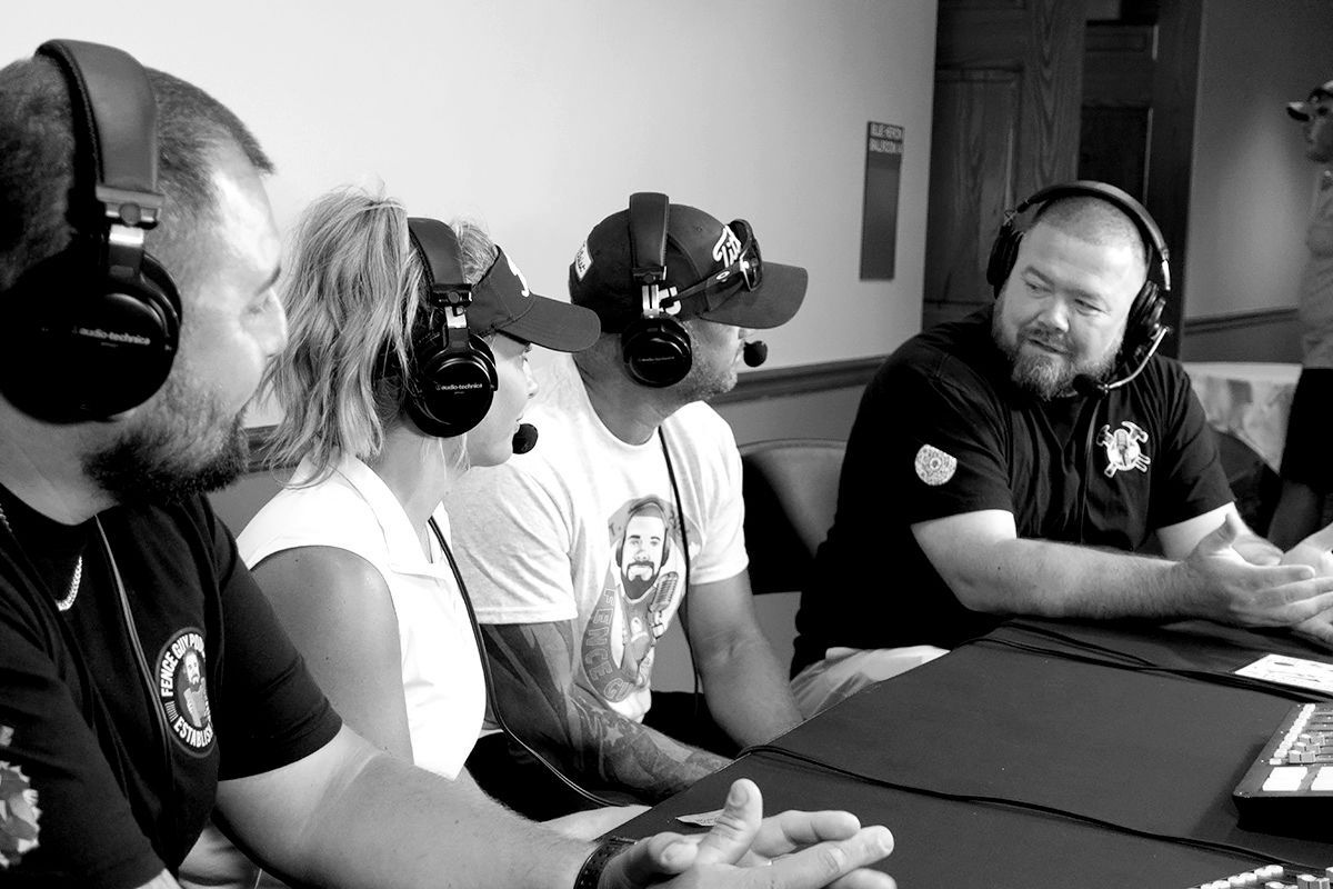 People wearing VR headsets seated at a table in a studio, talking and gesturing