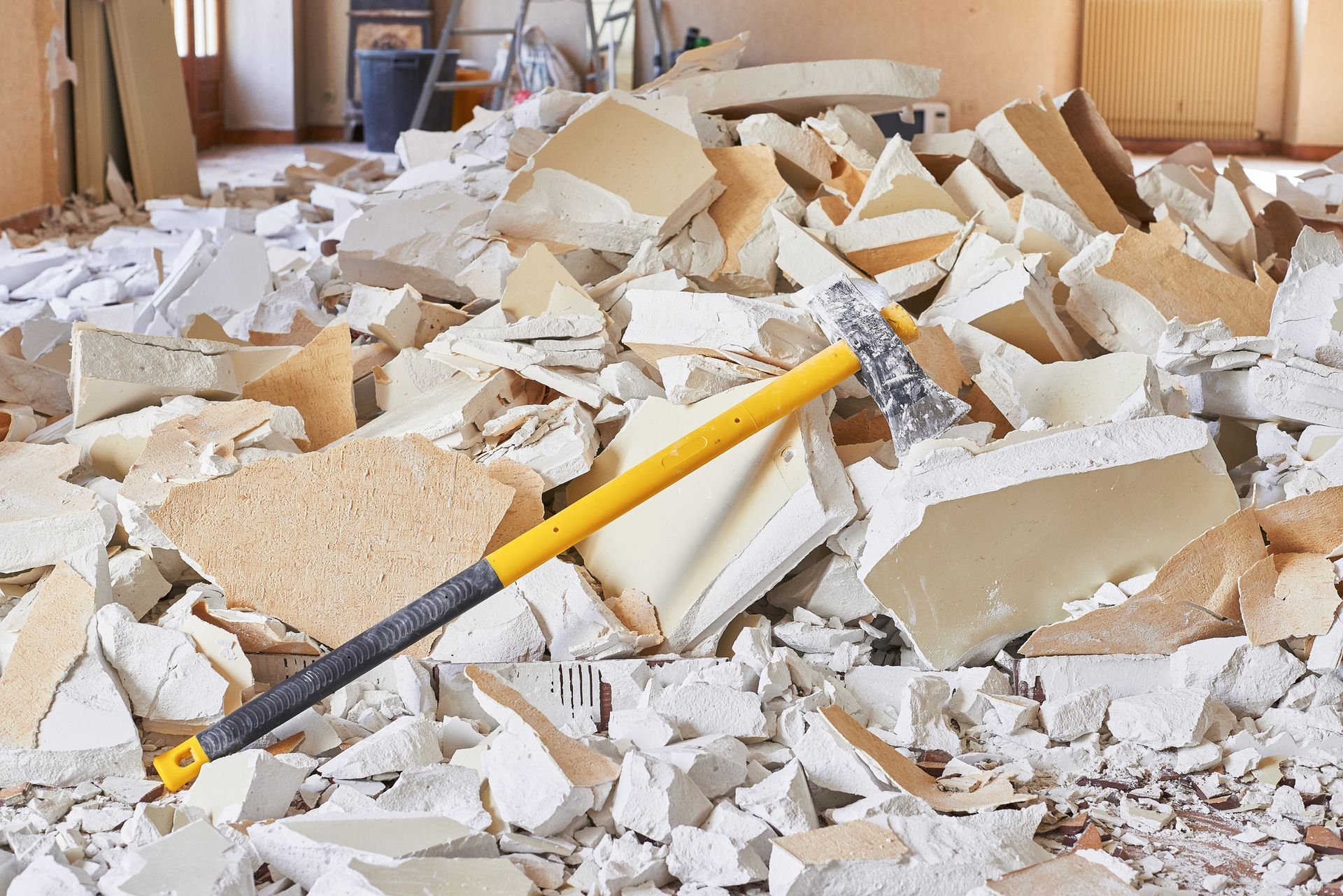 A hammer is laying on top of a pile of bricks.