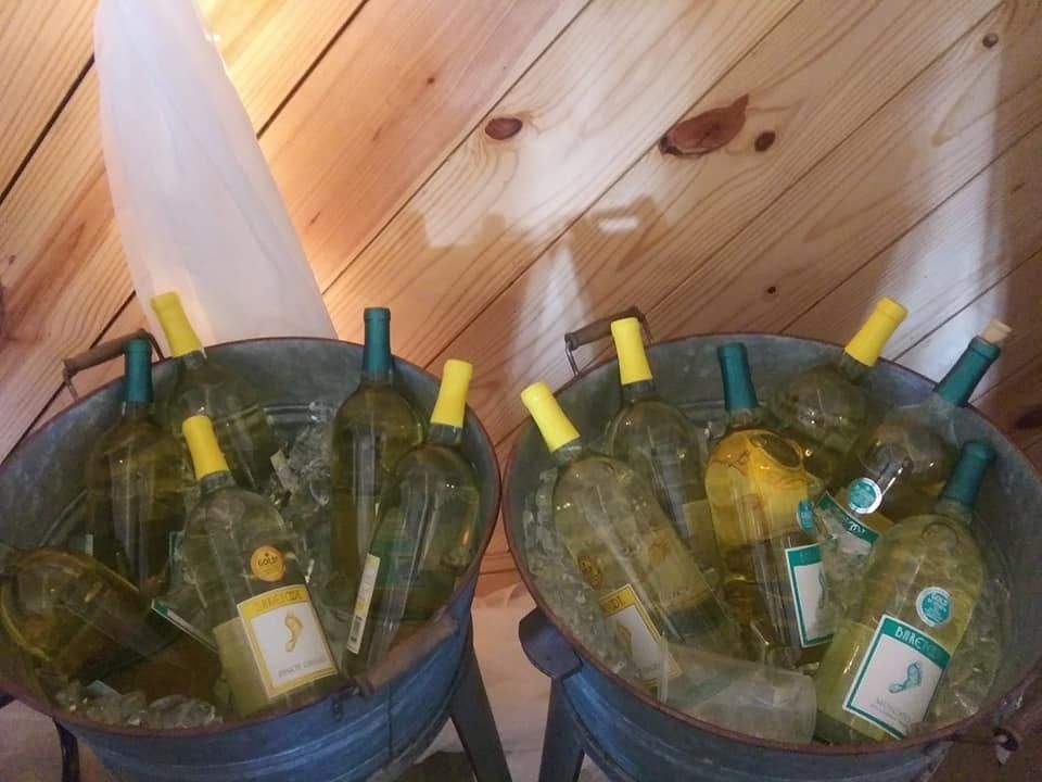 Two blue buckets filled with empty glass bottles against a wooden wall.