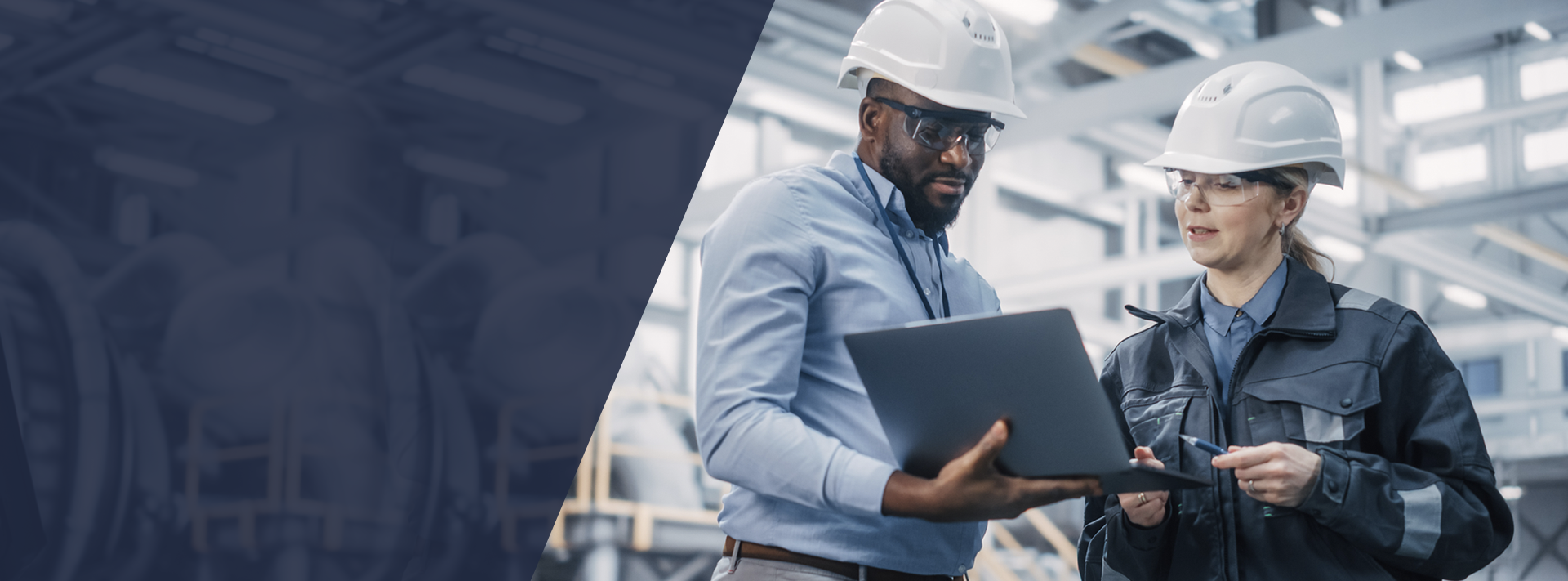 A man and a woman are looking at a laptop in a factory.