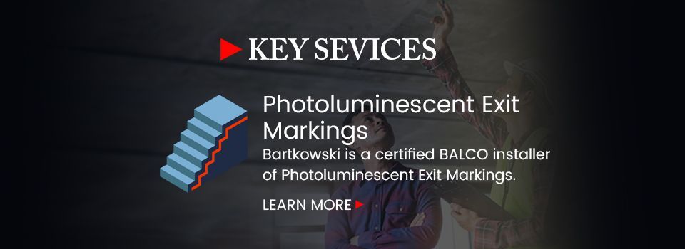 A sign that says key services photoluminiscent exit markings
