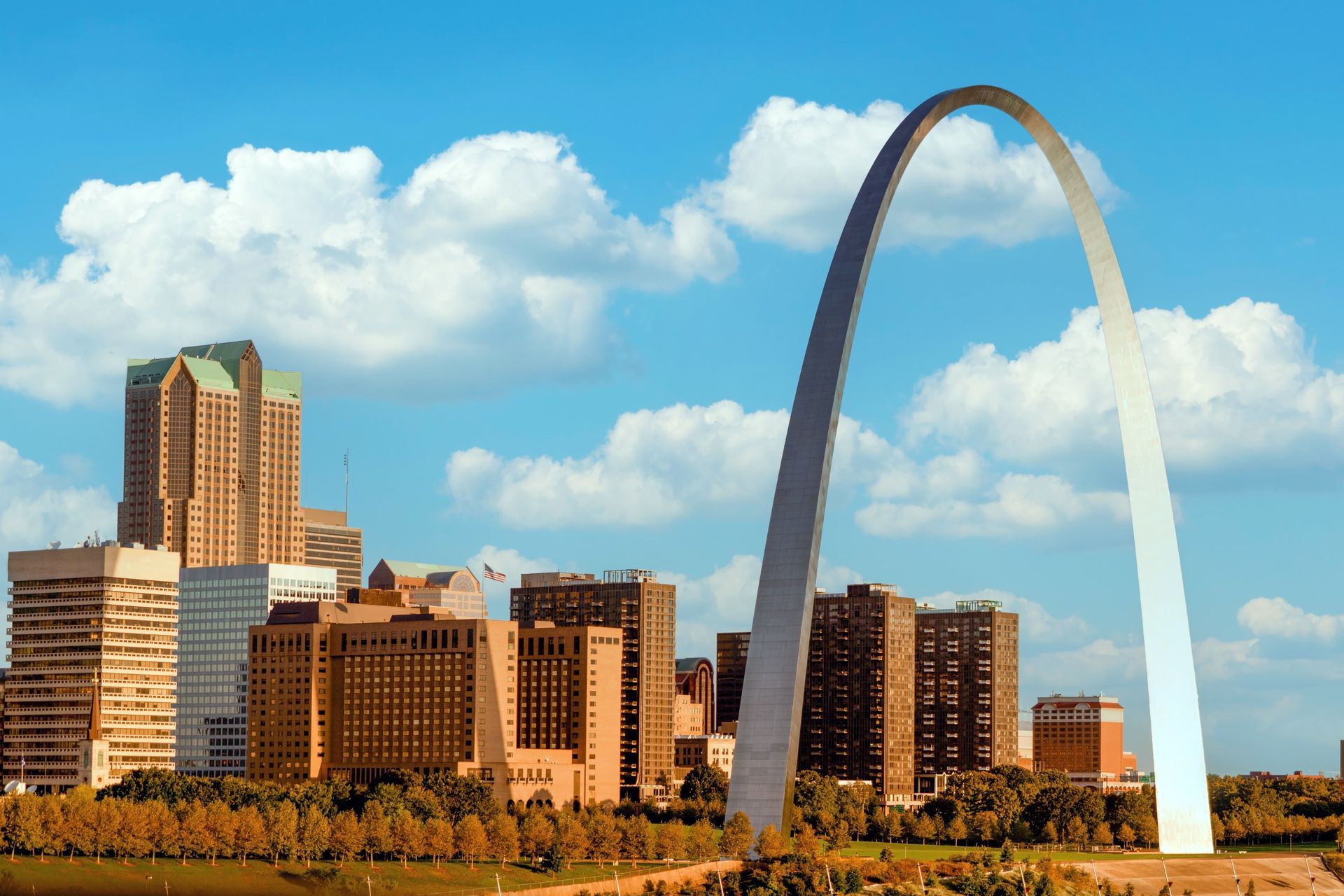 St. Louis skyline with the Gateway Arch against a blue sky and clouds