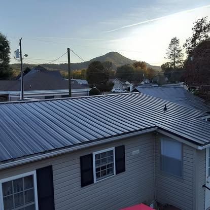 Rooftops at sunset with a mountain in the distance and utility poles overhead