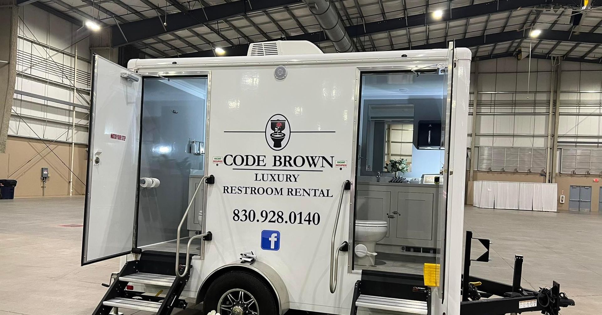 White food truck in warehouse, side panel open with a 