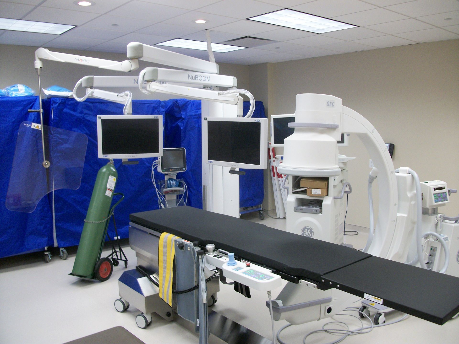 An operating room with a surgical table and monitors