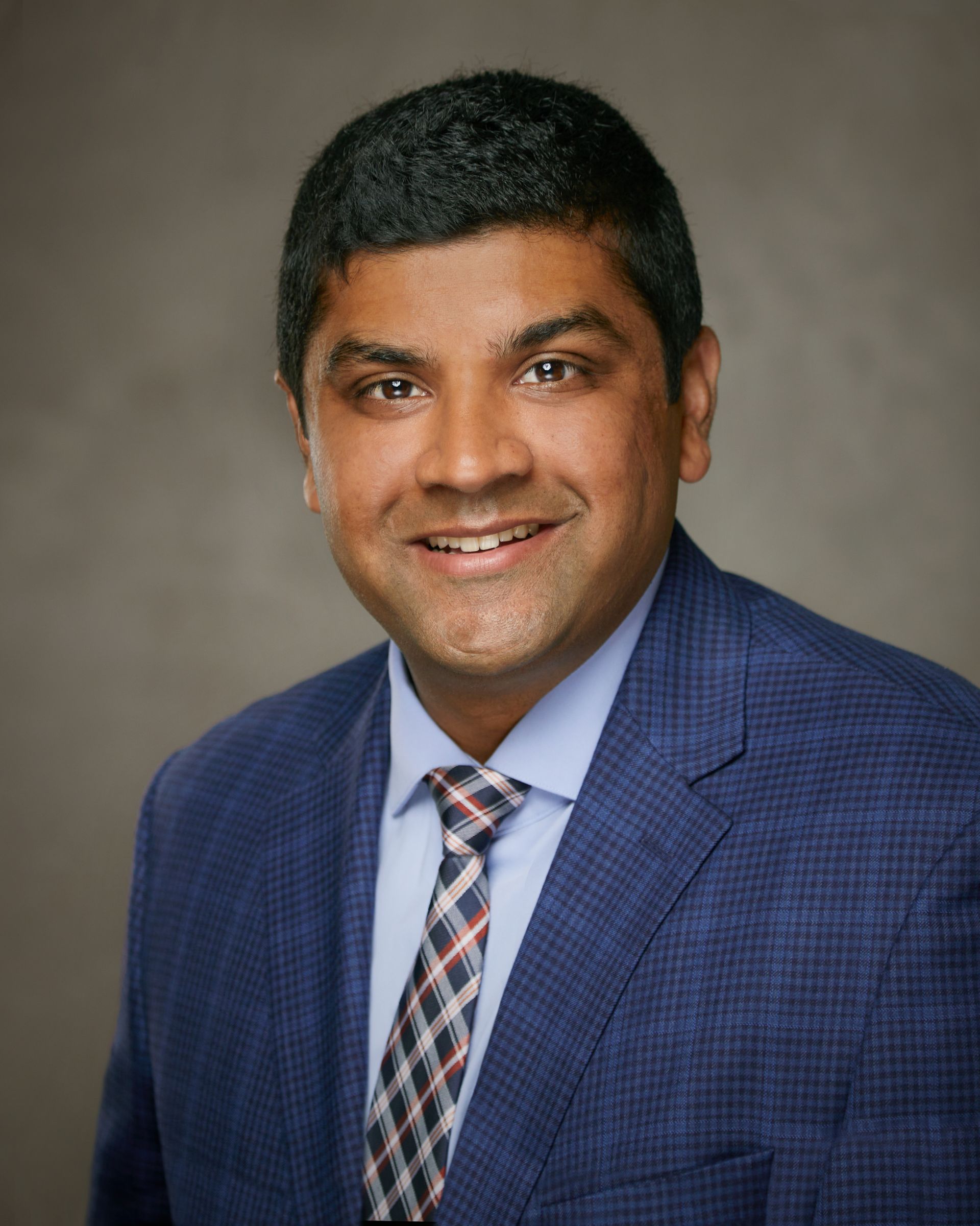 A man in a suit and tie is smiling for the camera.