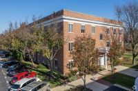 An aerial view of a large brick building with cars parked in front of it.