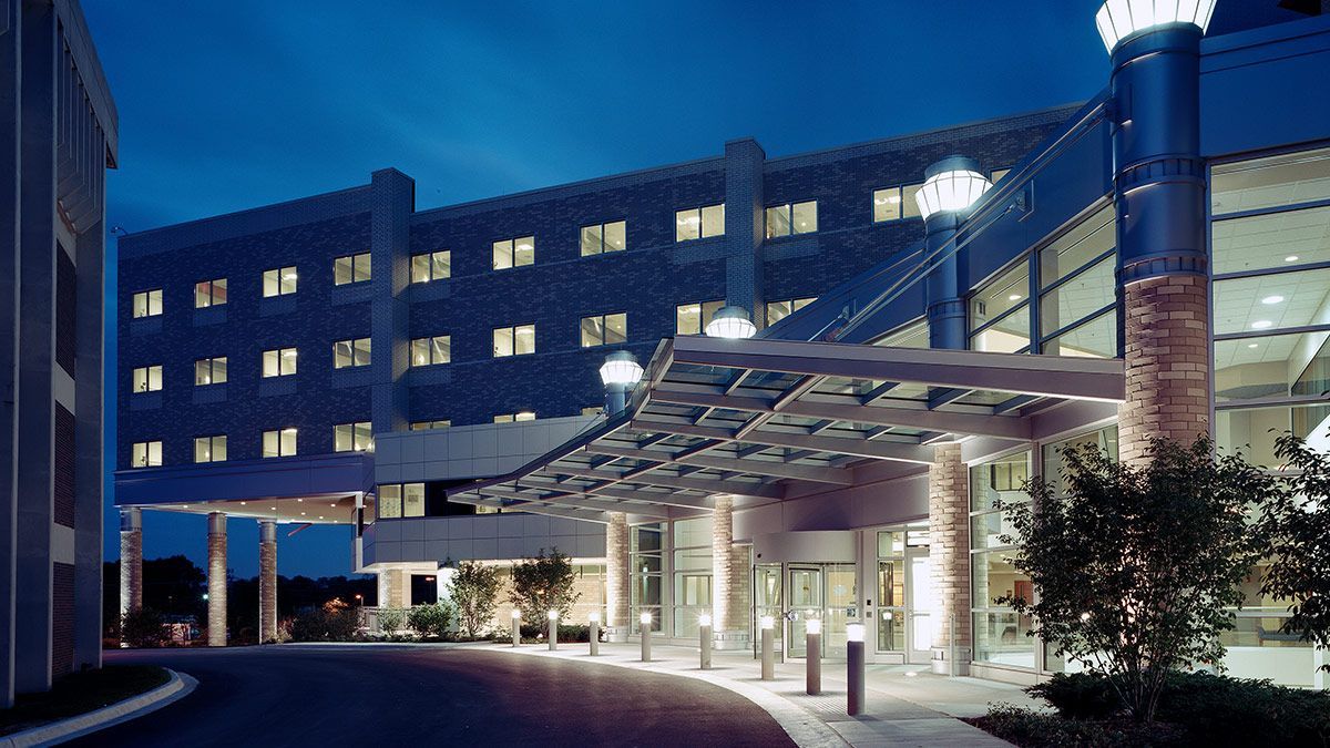 A large building with a canopy over the entrance at night