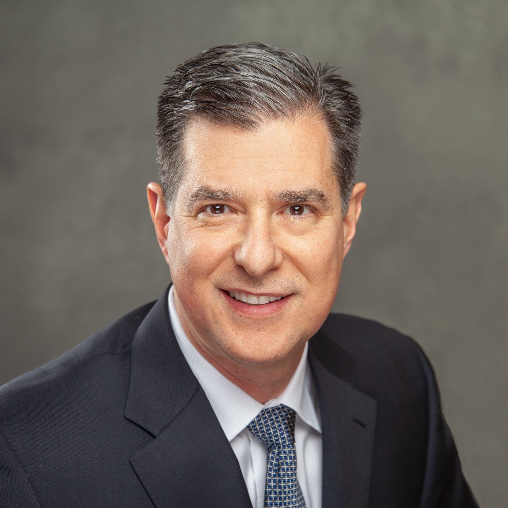 A man in a suit and tie is smiling for the camera.