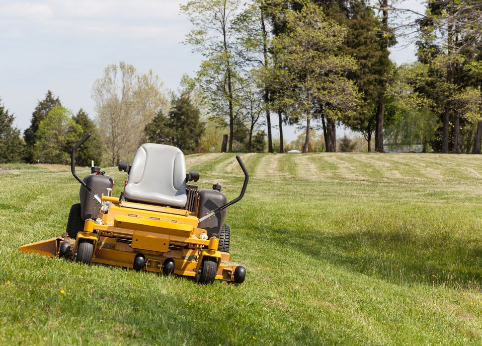 Yellow Riding Lawn Mower On A Grassy Hill, Cutting Grass — Stihl Shop Atherton In Atherton, QLD