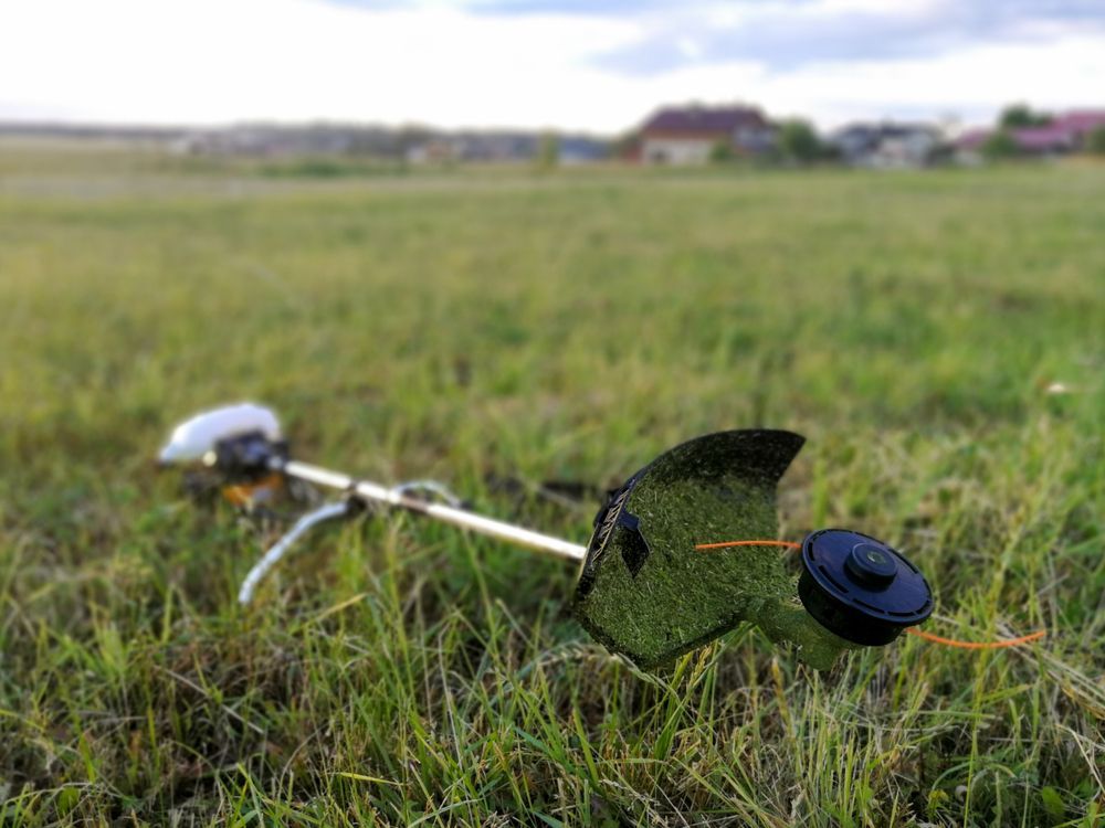 String Trimmer Lying In Tall Grass — Stihl Shop Atherton In Atherton, QLD