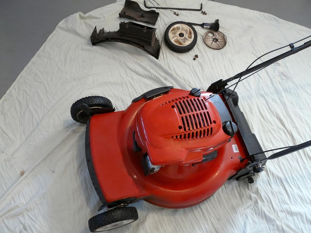 Red Lawnmower With Detached Parts On White Sheet — Stihl Shop Atherton In Mareeba, QLD