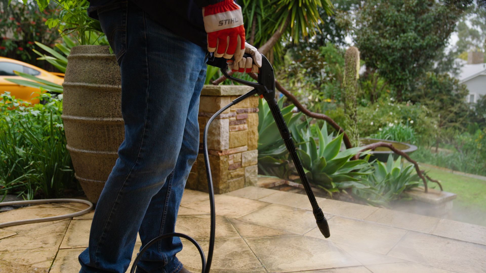 Person Pressure Washing A Stone Patio Outdoors — Stihl Shop Atherton In Atherton, QLD