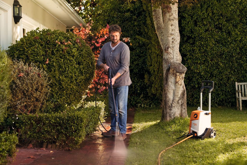 Person In Pants And Shoes Power Washing A Concrete Surface — Stihl Shop Atherton In Atherton, QLD