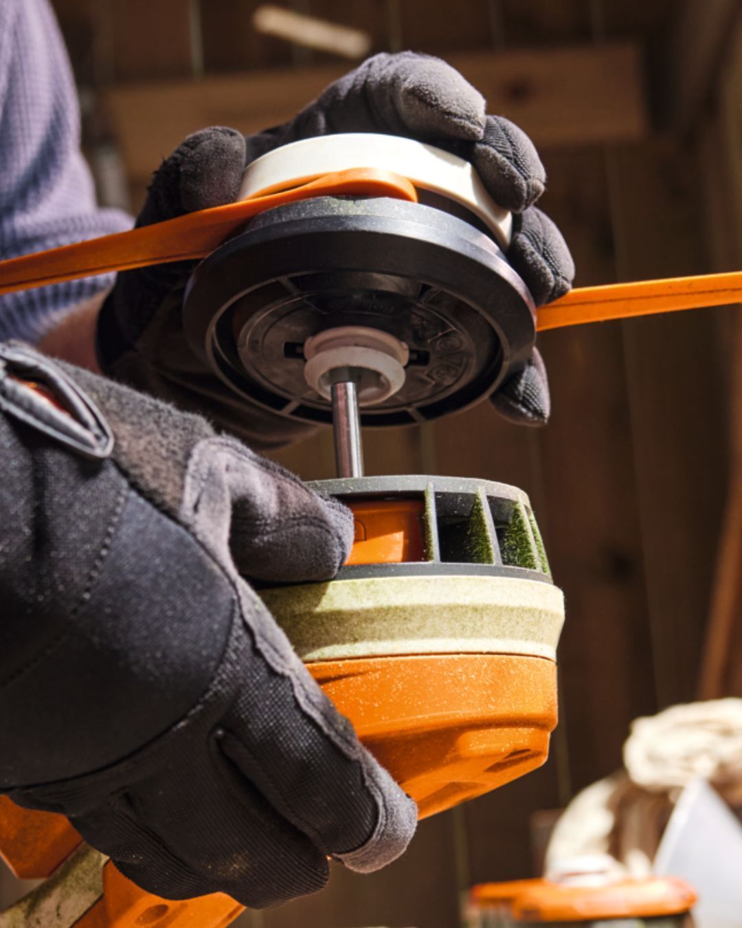 Person Assembling Weed Eater Head, Wearing Gloves. Orange And Black Parts Visible — Stihl Shop Atherton In Atherton, QLD
