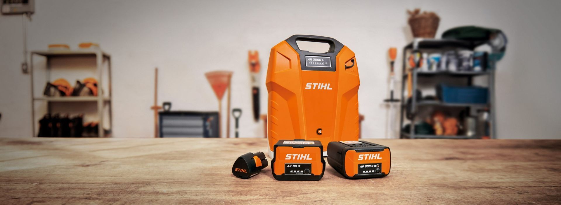 Orange Stihl Batteries And Charger In A Garage Setting — Stihl Shop Atherton In Atherton, QLD