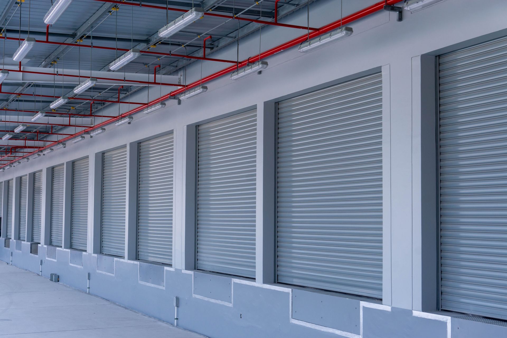Commercial dock levelers installed along loading docks with roll up warehouse doors. Commercial dock levelers installed along loading docks with roll up warehouse doors.