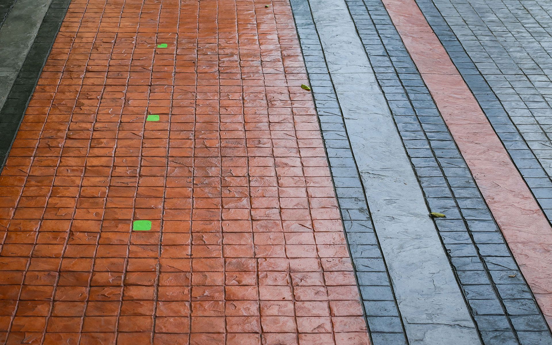 A brick walkway with a green square in the middle