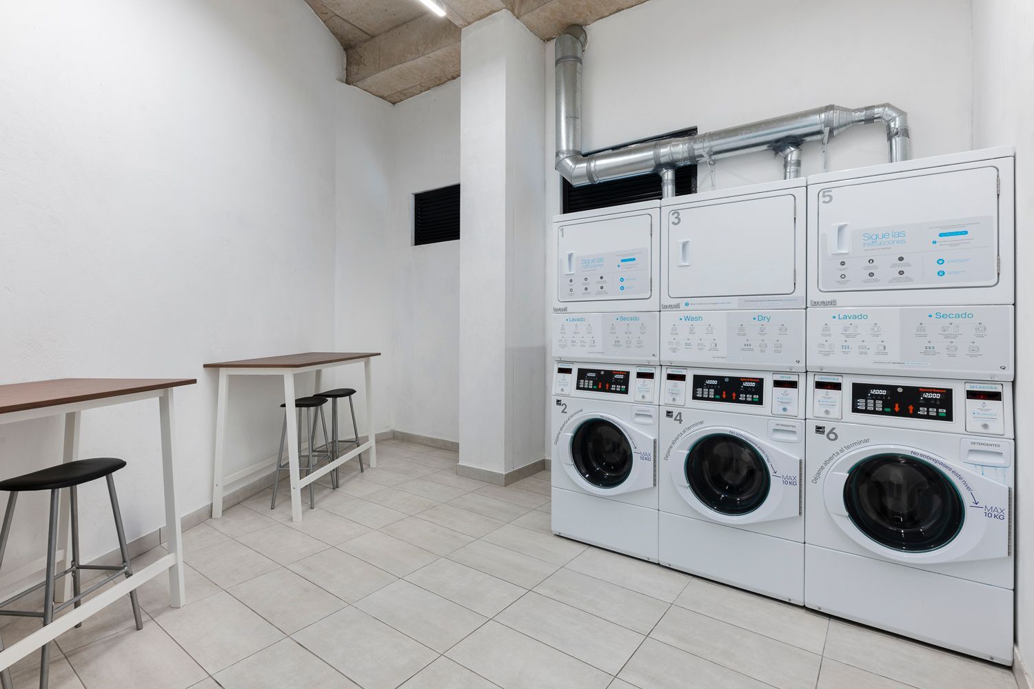 Área de lavandería con lavadoras y secadoras en apartamentos amoblados bogota
