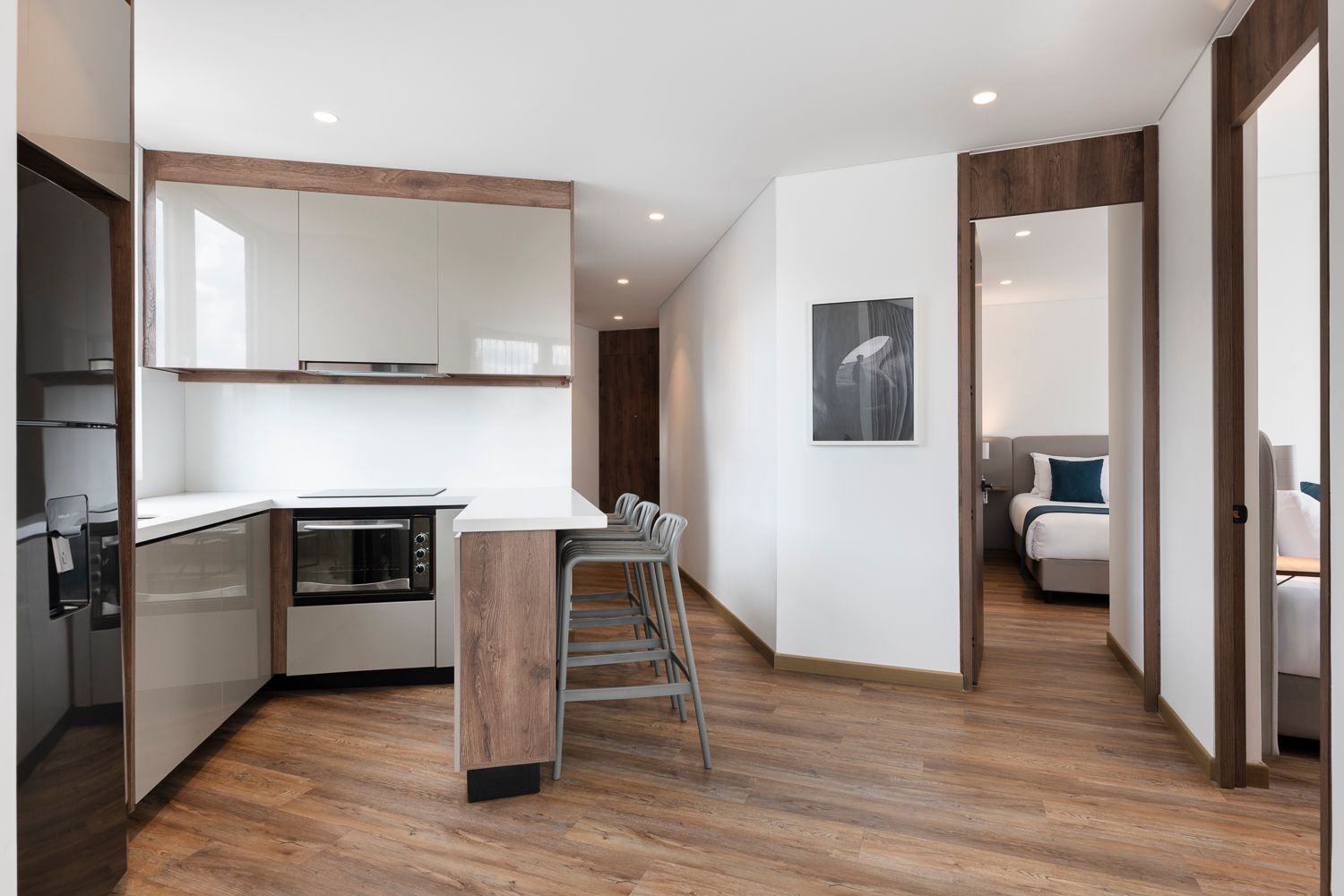 Cocina integral con barra estilo americano y vista al dormitorio en las apartasuites en bogota