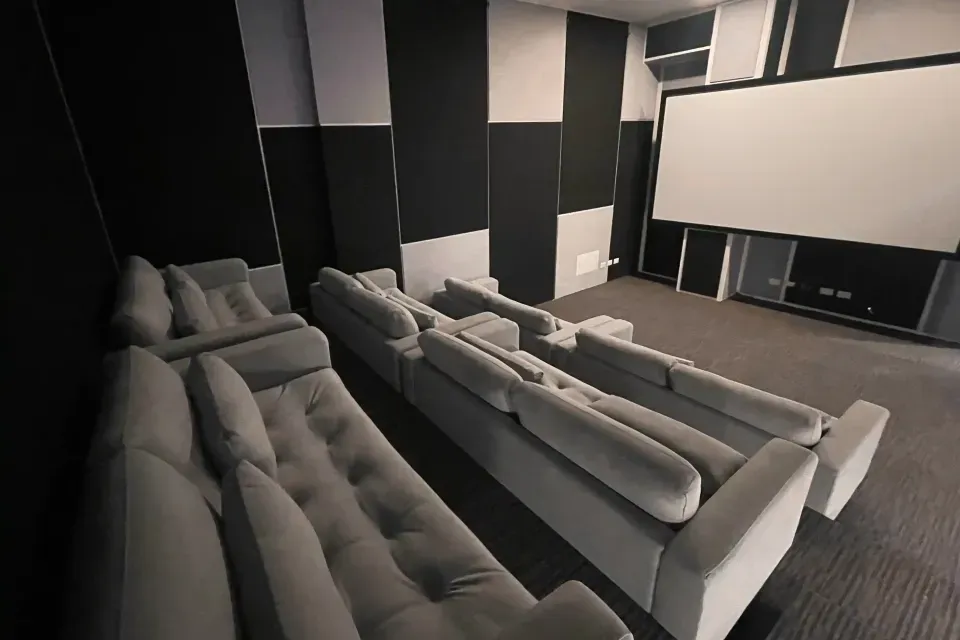 Sala de cine o lounge interior, amenidad de apartahotel en Bogotá con gimnasio y coworking para descanso después del trabajo o reuniones.