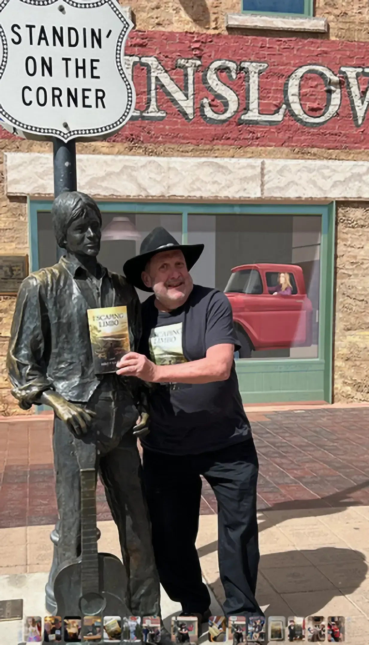 Man posing with a guitar statue at the 
