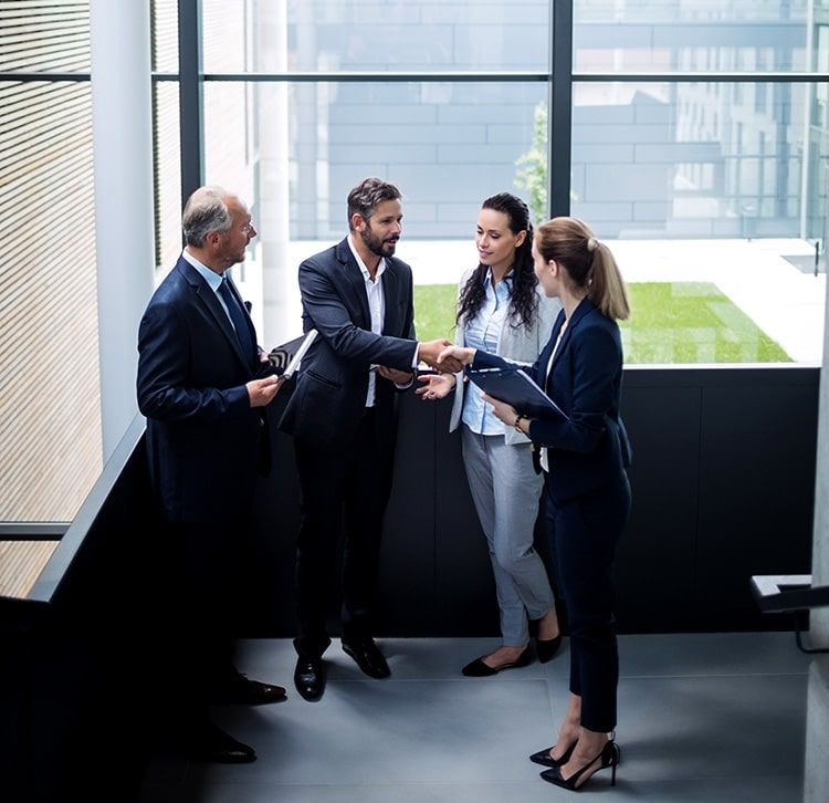 Un grupo de empresarios se dan la mano en una oficina.
