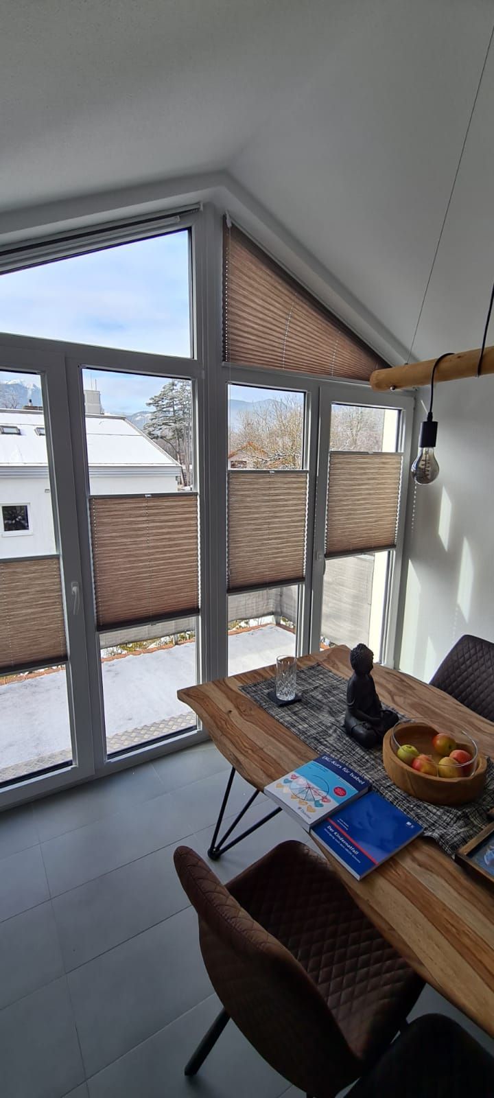 Ein Esszimmer mit Tisch und Stühlen und einem großen Fenster.