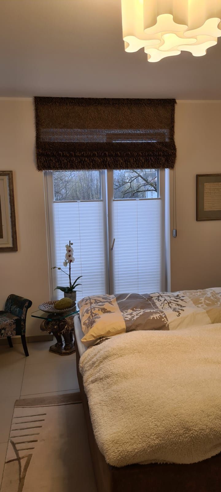 Ein Schlafzimmer mit einem Bett und einem Fenster mit Jalousien.