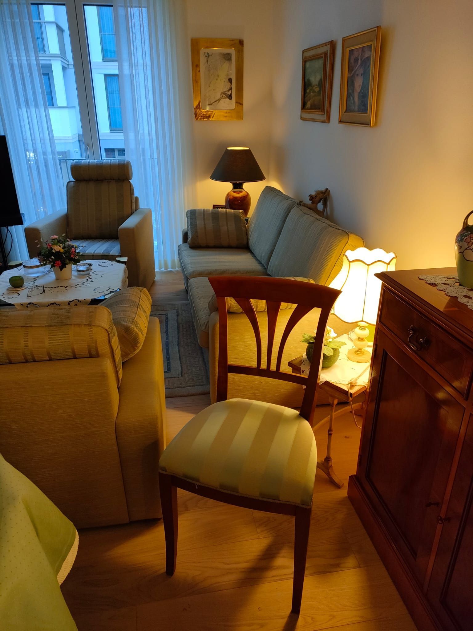 Ein Wohnzimmer mit einer Couch, einem Sessel und einer Lampe