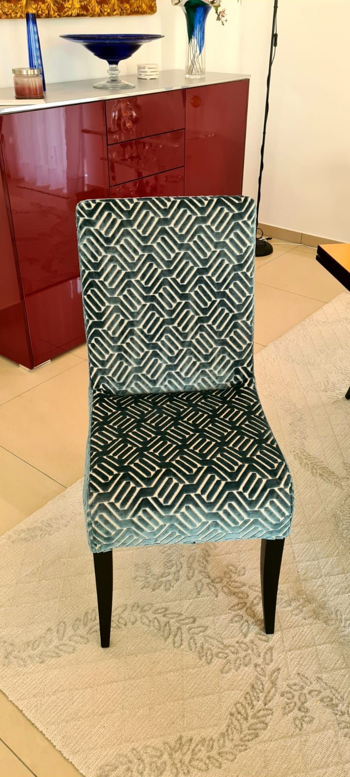 Ein Stuhl mit einem Muster steht auf einem Teppich in einem Wohnzimmer.