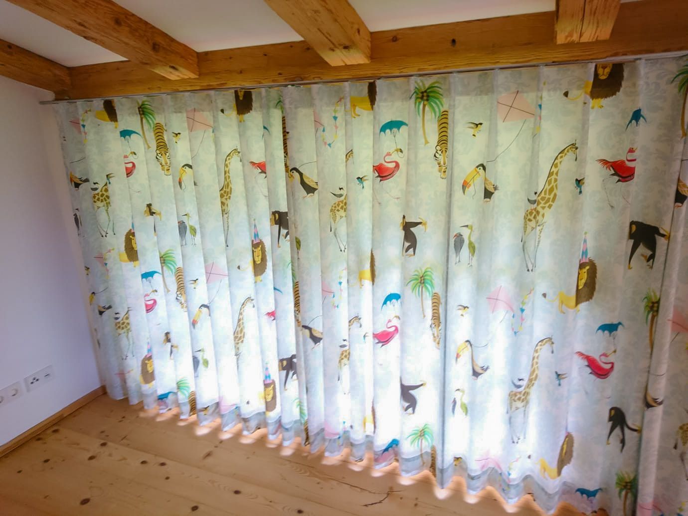Ein Zimmer mit vielen Vorhängen mit Tieren darauf