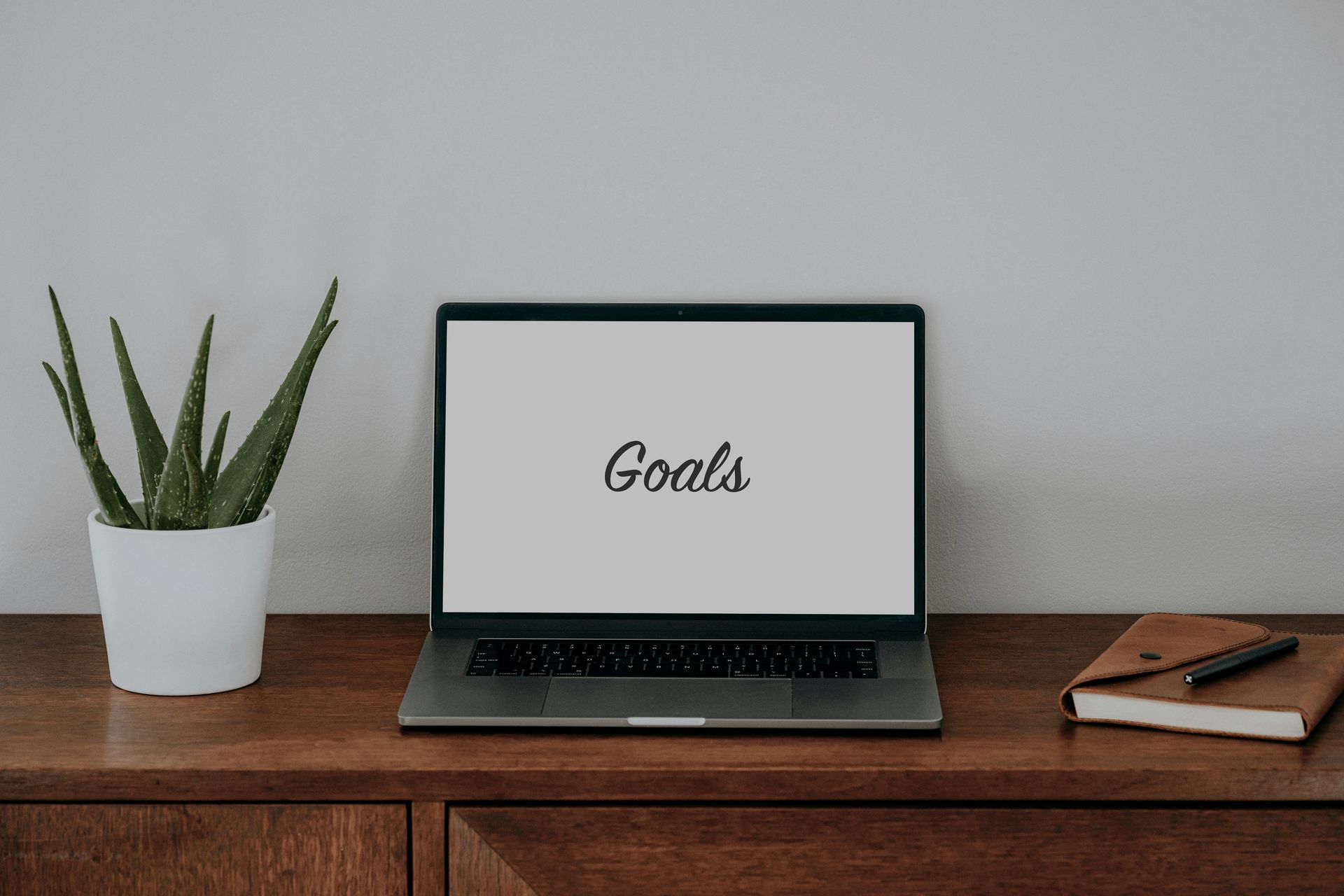 Computer on a desk with the word goals on the screen