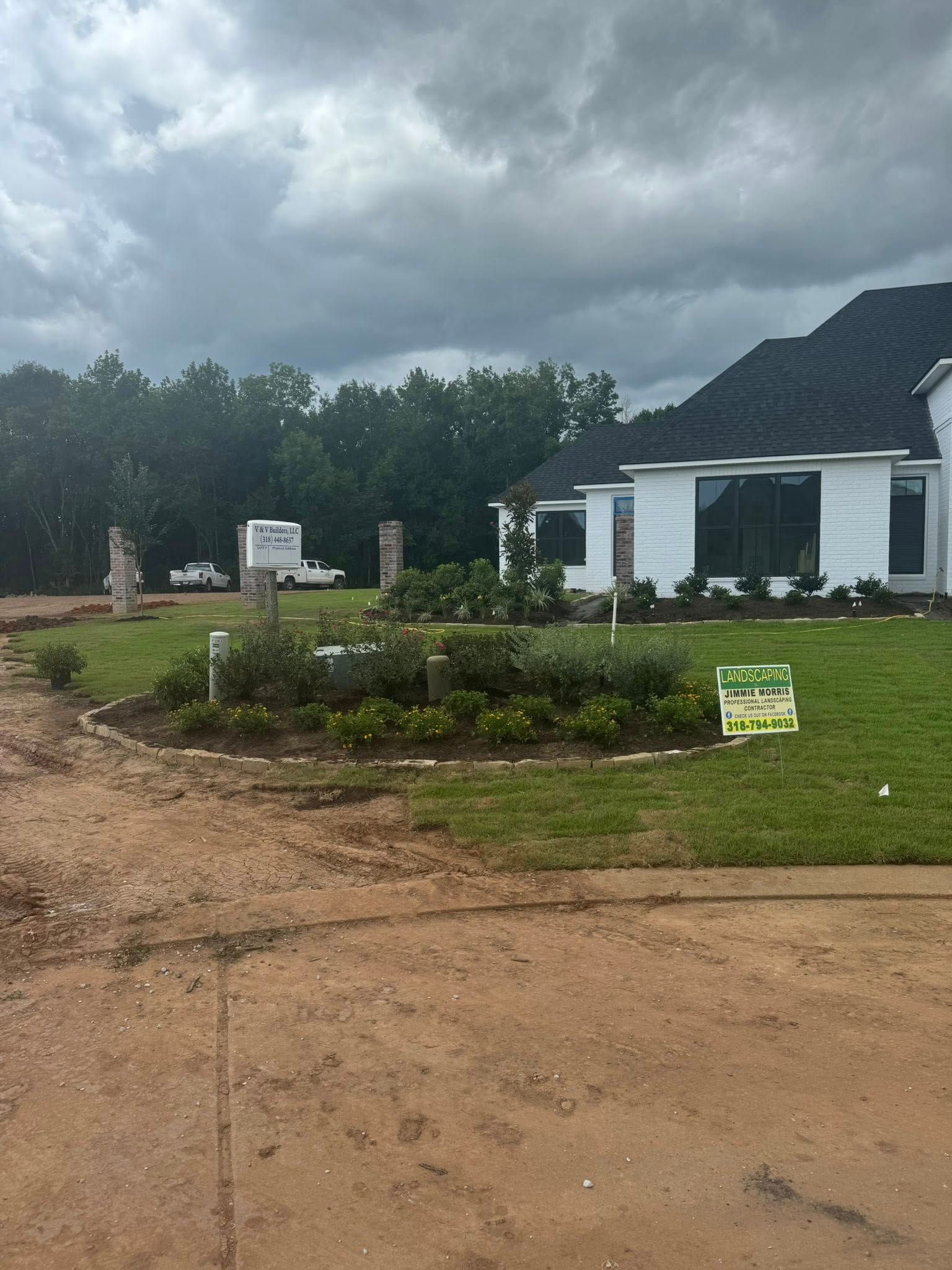 New house with landscaping under construction, cloudy sky, green grass.