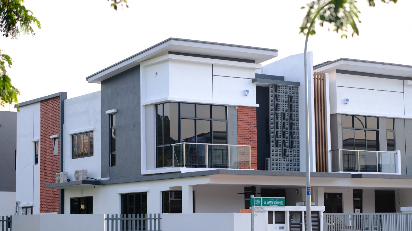 A modern two-story suburban house with a white and gray exterior, large windows, and a glass-paneled balcony.