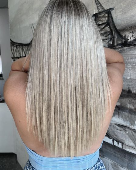 A Woman With Straight Blonde Hair Is Getting Her Hair Done In A Salon — Genesis Hair and Beauty In Port Kembla, NSW