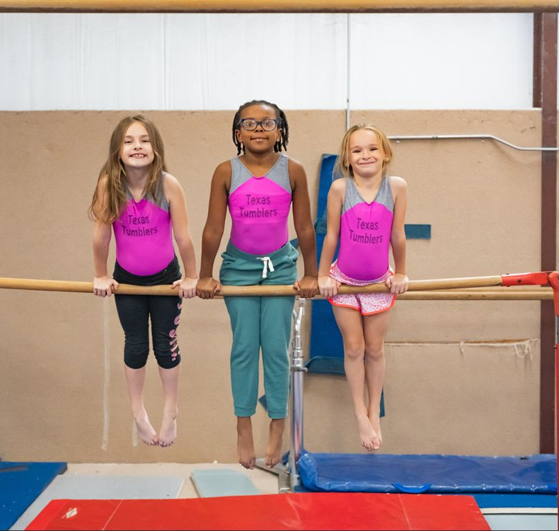 A group of young girls are posing for a picture in a dance studio.